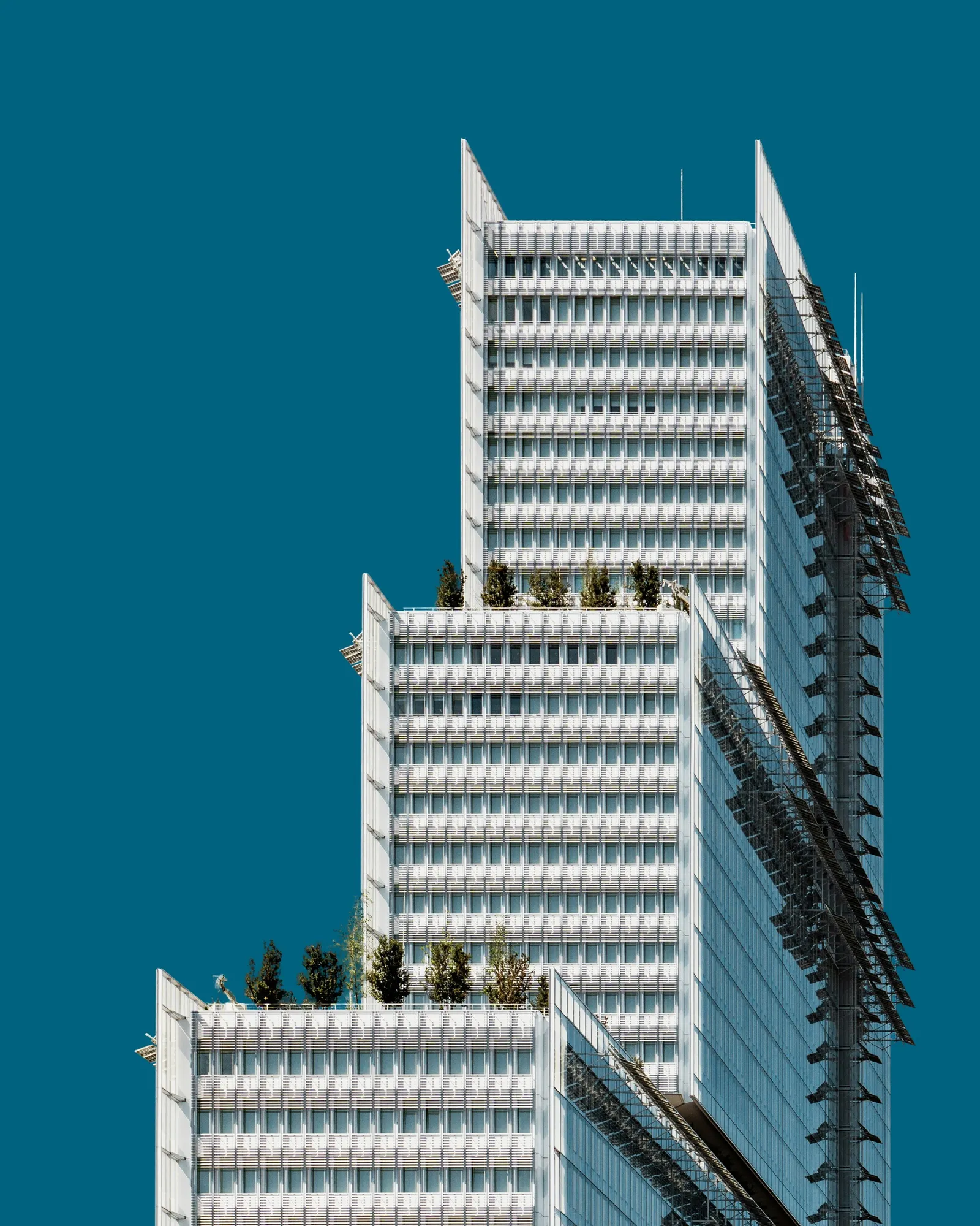 Modern engineered high-rise headquarters against a deep blue sky